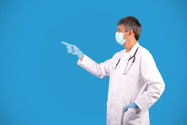 Profesyonel Doktor Mavi Arka Planda Duran Boş Alanı Işaret Ediyor — Stok fotoğraf