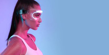 Spor teknisyenleri. Pembe ve Mavi Neon Stüdyo Arkaplanının Üzerinde Duran Beyaz Giysi Giyen Çekici Kadın Pozisyonunun Profil Portresi, VR gözlüğü, Kopya Boşluğu Olan Panorama