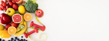 Meyveler, böğürtlenler, sebzeler, mezura ve dambıllar, beyaz stüdyo arka planında izole edilmiş, panorama, boş alan, üst manzara. Sağlık, reklam ve teklif, diyet, kilo kaybı