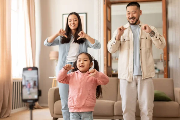 ソーシャルメディア楽しい 陽気な日本の家族インフルエンサーは 家で電話で赤ちゃんの娘とダンスビデオを撮影し オンラインログのコンテンツを作成します 楽しい親と子供のブログアドベンチャー — ストック写真