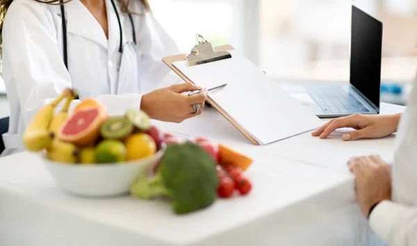 Ευρωπαία Μεσήλικη Γυναίκα Γιατρός Διατροφολόγος Λευκό Παλτό Δείχνουν Πρόγραμμα Διατροφής — Φωτογραφία Αρχείου
