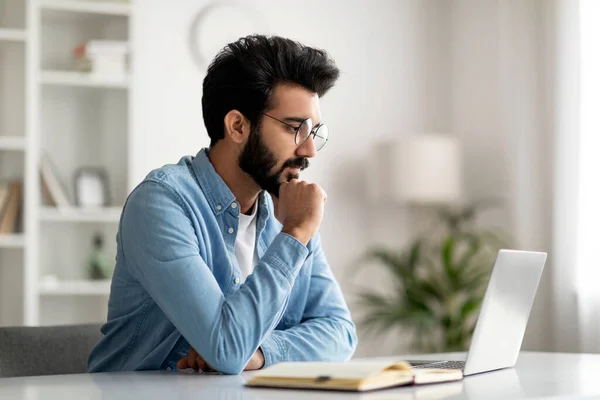 Pensive Young Indian Male Freelancer Brille Arbeiten Mit Laptop Home — Stockfoto
