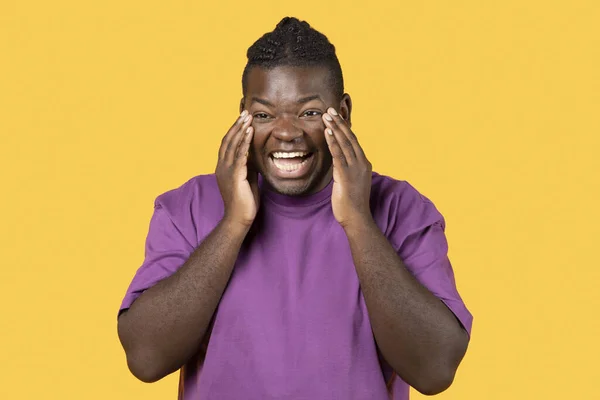 Lol 黑人男人笑着大声摸着脸看着站在黄色工作室背景上的相机 穿着便衣紫色T恤 积极的情感 欢笑的概念 — 图库照片
