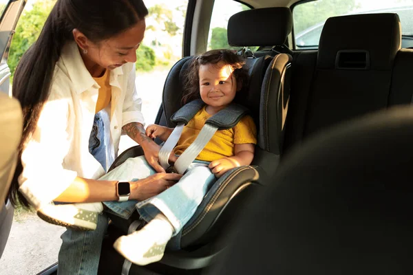 一路平安 中国妈妈确保孩子们的安全 保证孩子们坐在车座上的女儿们顺利 安全地乘坐汽车 调整汽车座椅上的安全带 — 图库照片