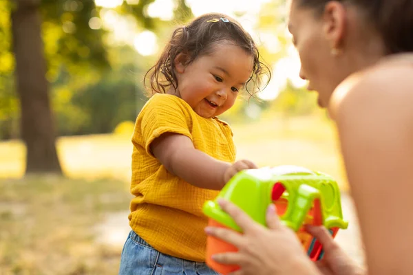 Asian Mommy Giving Her Baby Daughter Plastic Toy Playing Outdoors — Stock Photo, Image