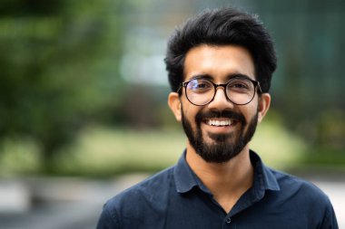 Kendine güveni tam Hintli iş adamı yöneticisi modern büyük şehirde duruyor, gelecekteki iş başarısının hayalini kuruyor, yeni hedefler, iş vizyonu ve liderlik kavramı düşünüyor, kopyalama alanı yaratıyor.