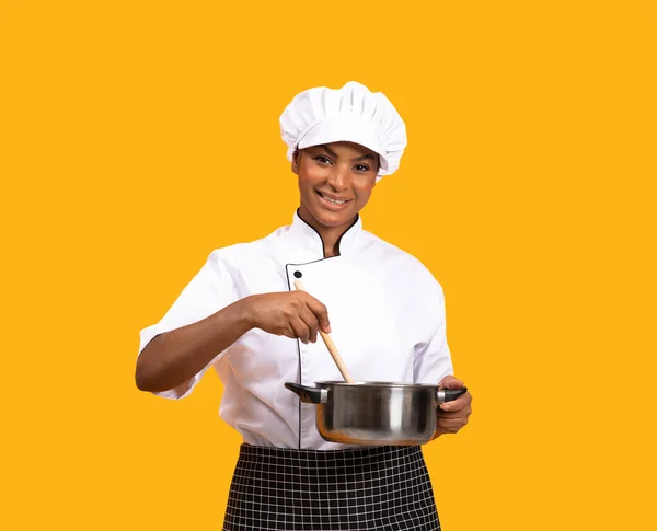 Saucepan Spatula Karıştırıcı Yemekleri Olan Kameraya Gülümseyen Güzel Siyah Aşçı — Stok fotoğraf