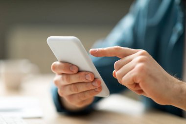 Ofiste otururken akıllı telefon kullanan, cep telefonu tutan, cep telefonu kullanan, yeni cep telefonu uygulamasına göz gezdiren veya internetten alışveriş yapan,