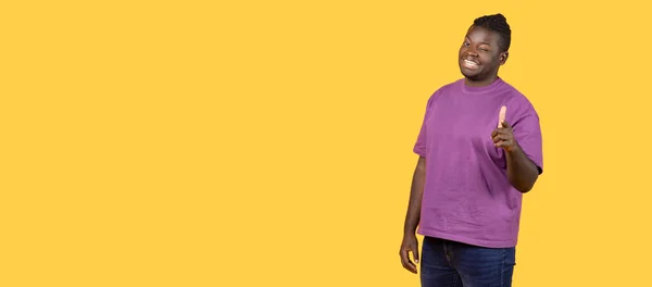 ピック 幸せなアフリカ系アメリカ人男性の肖像画は インデックスフィンガーを指し カメラにウィンキングアイを指し 黄色の背景にポーズします 選択し ジェスチャーを示す男 パノラマ フリースペース — ストック写真