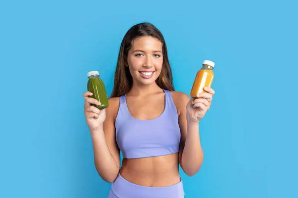 Positive Millennial European Woman Sportswear Thinks Shows Bottles Smoothie Isolated — Stock Photo, Image