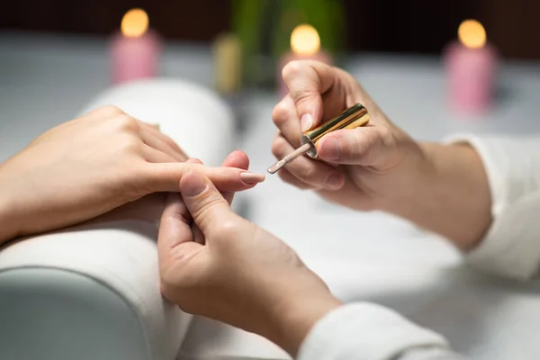 stock image Closeup Of Female Hands During Manicure Routine At Nail Studio Indoor, While Professional Manicurist Lady Applying Beige Nude Gel Polish At Clients Fingernails At Beauty Salon. Selective Focus