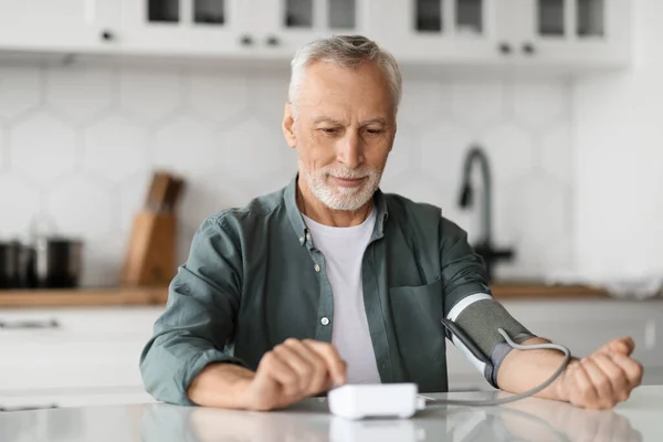 Älterer Mann Überprüft Blutdruck Mit Oberarmmonitor Kücheninneren Lächelnder Älterer Herr — Stockfoto