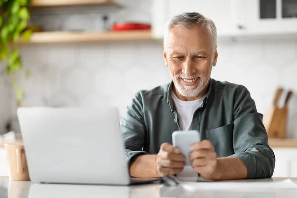 Lächelnder Senior Der Hause Smartphone Und Laptop Nutzt Glücklicher Älterer — Stockfoto