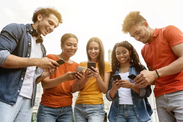 Feliz Grupo Estudiantes Usando Sus Teléfonos Inteligentes Mientras Relajan Juntos — Foto de Stock