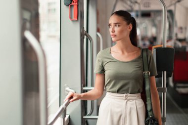 Şehir Ulaşım Hüsranı. Modern Tramvayın İçinde Duran Hoşnut Olmayan Kadın Şehir Yolculuğu Meydan Okumasıyla Karşı Karşıyayız. Mutsuz yolcunun toplu taşıma aracında vurulması. Kötü Şehir Ulaşım Konsepti
