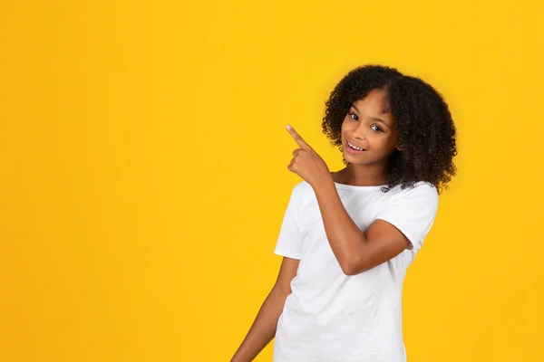 Beyaz Tişörtlü Mutlu Afro Amerikan Kız Parmakla Göstererek Boşluğa Turuncu — Stok fotoğraf