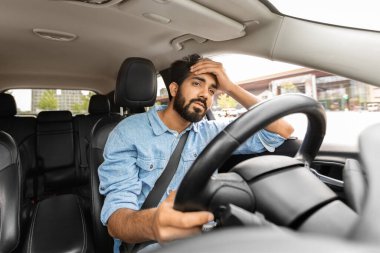 Kazadan sonra araba süren adam ümitsizliğe düşmüş. Üzgün sürücü, yolda stresli durumlar, modern şehirde hızlı ritim. Mutsuz, yorgun Hintli adam direksiyonu otomatikte tutuyor, elini kafasına bastırıyor.