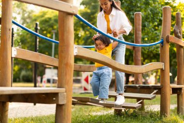 Koreli Anne, Kızına Sallanan Köprü 'de Rehber, Oyun Bahçesi Macerası' nda Yürüyen Çocukla Müdahale, Summer City Park 'ta Dışarıda Oyun Zamanı' nın tadını çıkarıyor. Kırpılmış Vuruş