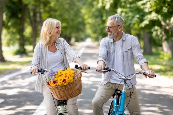 快乐活跃的老夫妇一起骑自行车在公园里 快乐成熟的夫妇在户外骑复古自行车时一起玩乐 享受老年人的体育活动 — 图库照片