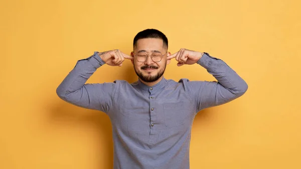 손가락과 Frowning와 아시아 사람의 초상화 안경을 노란색 스튜디오 공간에 무언가를 — 스톡 사진