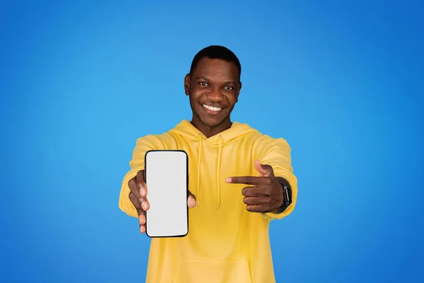 Kapüşonlu Gülümseyen Afro Amerikan Adam Telefonu Boş Ekranla Işaret Ediyor — Stok fotoğraf