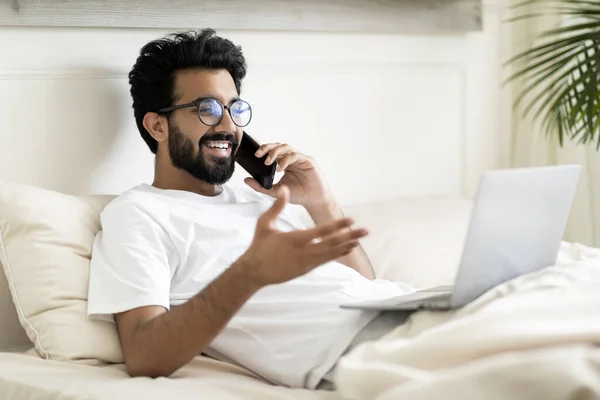 Ung Indian Man Talar Mobiltelefon Och Använda Laptop Medan Kopplar — Stockfoto