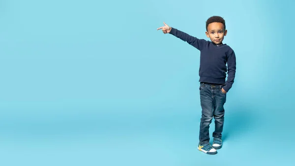 很好的提议高兴的黑人小男孩把目光投向了复制空间 展示了蓝色工作室背景 全景的广告设计空间 — 图库照片