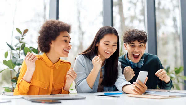 Spännande Multiracial Studenter Vänner Tittar Mobiltelefon Och Knyta Nävar Kontrollera — Stockfoto