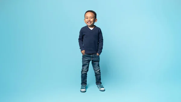 全长拍摄的快乐的非洲裔美国小男孩手挽手 站在蓝色工作室的背景上 对着摄像机 自由自在的空间微笑着 — 图库照片