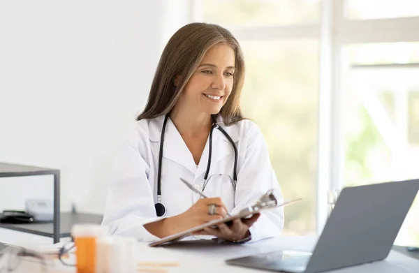 Cheerful Adult Caucasian Nutritionist Doctor White Coat Table Makes Notes — Stock Photo, Image