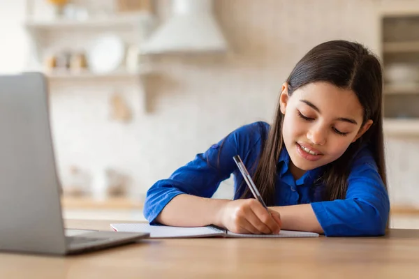Kaukainen Oppiminen Hymyilevä Koulu Tyttö Oppiminen Kannettavan Tietokoneen Kanssa Kotona — kuvapankkivalokuva