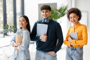 - Öğrencilik. Modern dinleyiciler arasında poz veren mutlu uluslararası üniversite öğrencileri, çalışma kitapları olan çeşitli gençler sınıfta kameraya gülümsüyor.