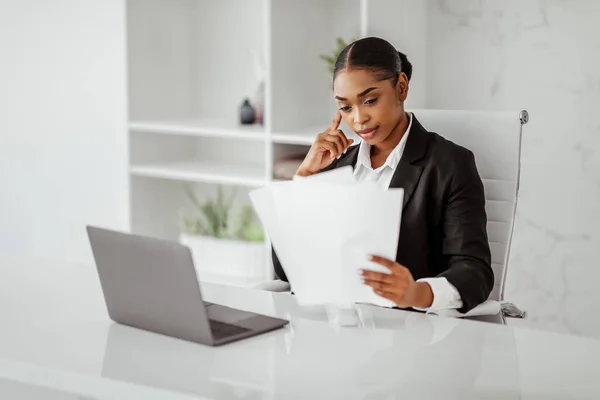 Evrakları Siyahi Kadını Gazete Okuyor Modern Ofisteki Dizüstü Bilgisayarın Önünde — Stok fotoğraf