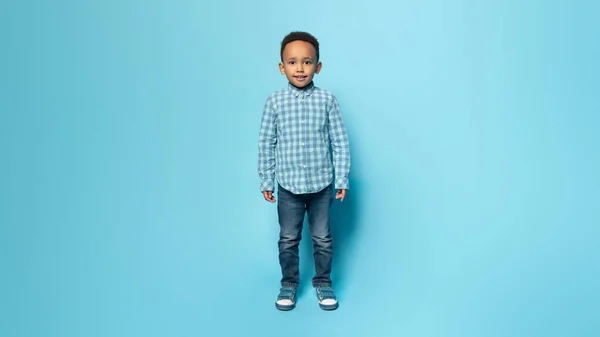 快乐可爱的小黑人男孩随意地站在蓝色的工作室背景 自由自在的空间 生活方式 孩子的情感 广告和提供 — 图库照片