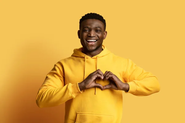 Sarı Kapüşonlu Kalp Şeklinde Bir Sembolle Göğsüne Ele Tutuşup Gülümseyen — Stok fotoğraf
