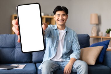 Harika bir uygulama. Gülümseyen Asyalı adam boş akıllı telefonu kamerada büyük beyaz ekranla gösteriyor, Ev İçi Mobil Reklamlar İçin Kopya Alanı 'nı gösteriyor. Telefon Teklifi İçin Model