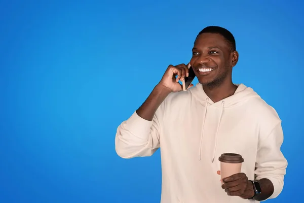 Счастливый Афроамериканец Тысячелетия Толстовке Звонит Телефону Наслаждается Чашечкой Кофе Вынос — стоковое фото