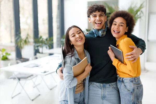 Tres Emocionados Estudiantes Internacionales Amigos Abrazando Sonriendo Cámara Posando Interior — Foto de Stock