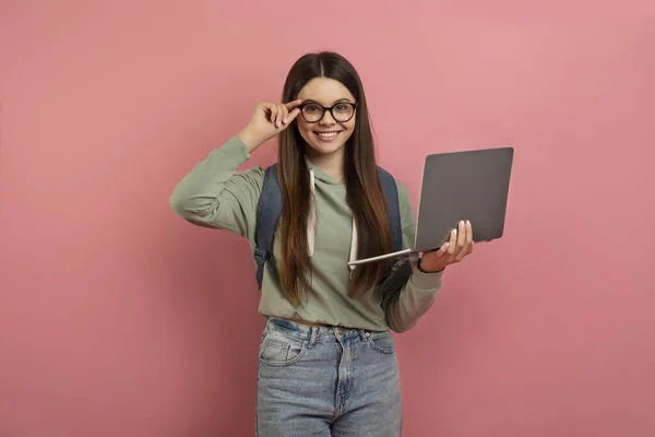 ピンクのスタジオの背景に立っている間 ラップトップコンピュータ 幸せなかわいい女性ティーンエイジャーと笑顔の十代の少女の肖像画 ピンクのスタジオの背景に立ってインターネットをブラウジング — ストック写真