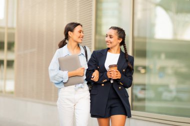 İki neşeli genç bayan sokakta yürüyor, öğle yemeği molası veriyor, sohbet ediyorlar. Üniversiteden eve dönen kadın öğrenciler, paket kahve içiyorlar, sohbet ediyorlar, yer kopyalıyorlar.