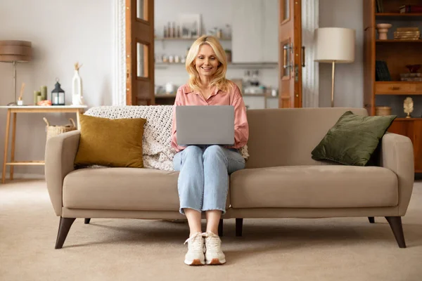 Evde Çalışan Dizüstü Bilgisayarlı Kapalı Koltukta Oturan Mutlu Olgun Bir — Stok fotoğraf
