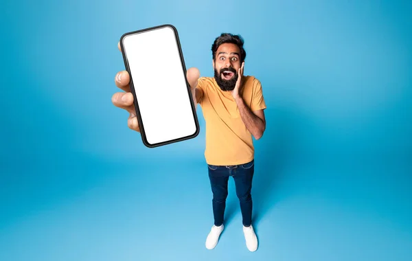 Удивительное Приложение Удивленный Индиец Держит Смартфон Белым Чистым Экраном Руке — стоковое фото