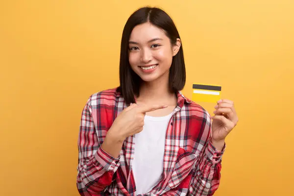Wesoła Japońska Zakupoholiczka Wskazująca Palcem Kartę Kredytową Polecająca Sprzedaż Żółtym — Zdjęcie stockowe