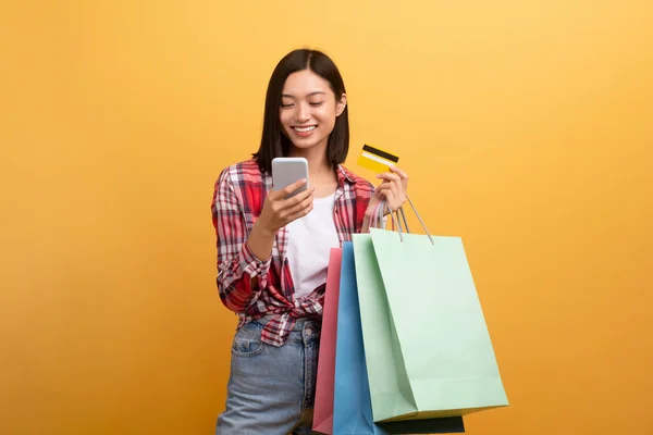 Raffreddare Sorridente Signora Asiatica Casuale Tenuta Borse Colorate Shopping Smartphone — Foto Stock