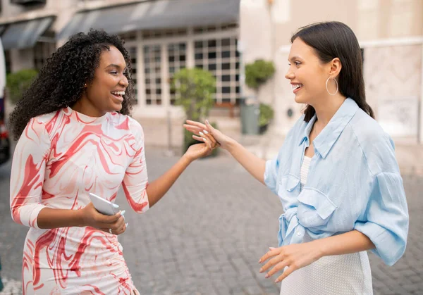 stock image Portrait Of Two Cheerful Multhiethnic Female Friends Laughing And Chatting Outdoors, Joyful Beautiful Young Girlfriends Meeting On City Street, Happy To See Each Other, Having Fun Outside