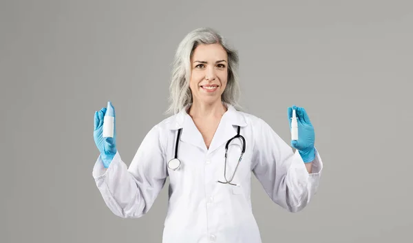 Lekarka Białym Płaszczu Pokazująca Butelki Medyczne Obu Dłoniach Reklamujące Leki — Zdjęcie stockowe