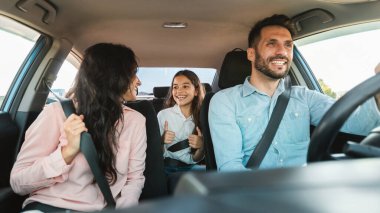 Otomatik satın alma ve kiralama. Yeni araba kullanan, şehirde test sürüşü yapan, yolculuğun ve panoramanın keyfini çıkaran beyaz mutlu bir aile. Ebeveynler ve kız çocukları tatillerini arabayla geçiriyorlar..