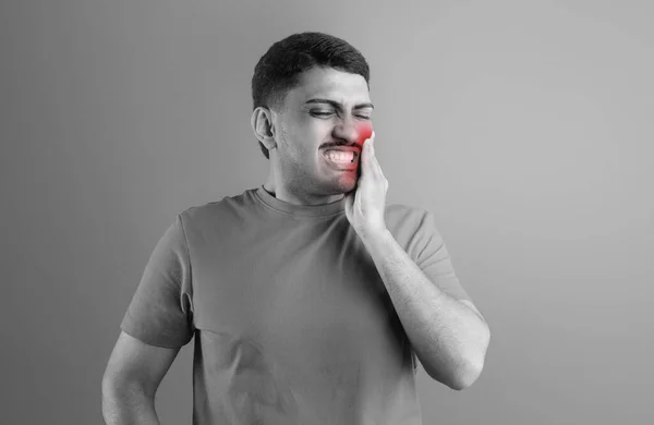 牙齿问题 年轻男子患有急性牙痛 触痛红肿 磨牙线 牙周炎 站在工作室的背景上 Bw注射 — 图库照片