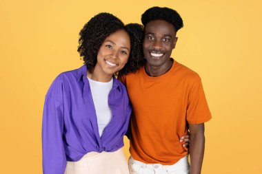 Gülümseyen siyah eş, sıradan bir şekilde kocaya sarılıyor, buluşmanın tadını çıkarıyor, birlikte vakit geçiriyorlar, sarı stüdyo arka planında soyutlanıyorlar. Aşk, ilişkiler, yaşam tarzı, reklam ve teklif, kapat