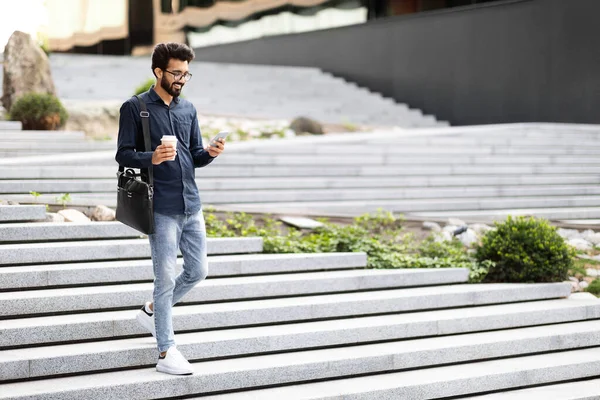 Ευτυχισμένος Νεαρός Ινδιάνος Που Κρατάει Smartphone Περπατώντας Εξωτερικούς Χώρους Στέλνοντας — Φωτογραφία Αρχείου